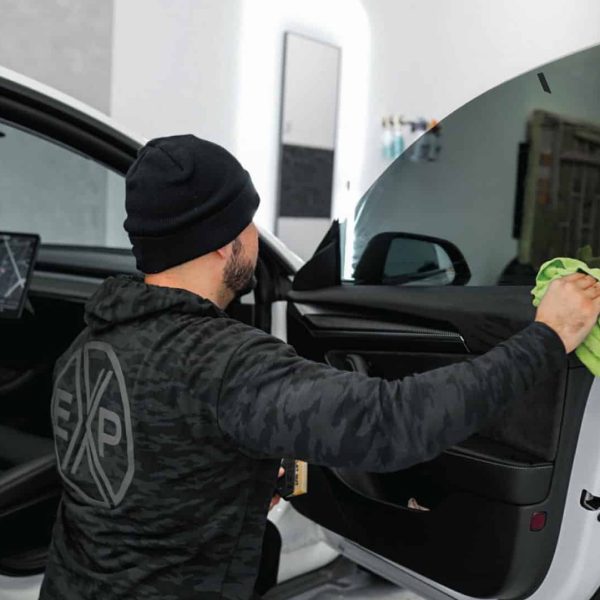 A TintBusiness employee tinting a Tesla front window in USA
